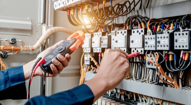Electrician using multimeter to test electrical installation and power lines